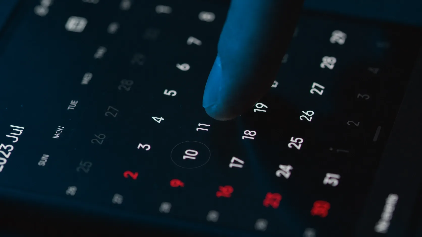 Finger tapping a date on a digital calendar