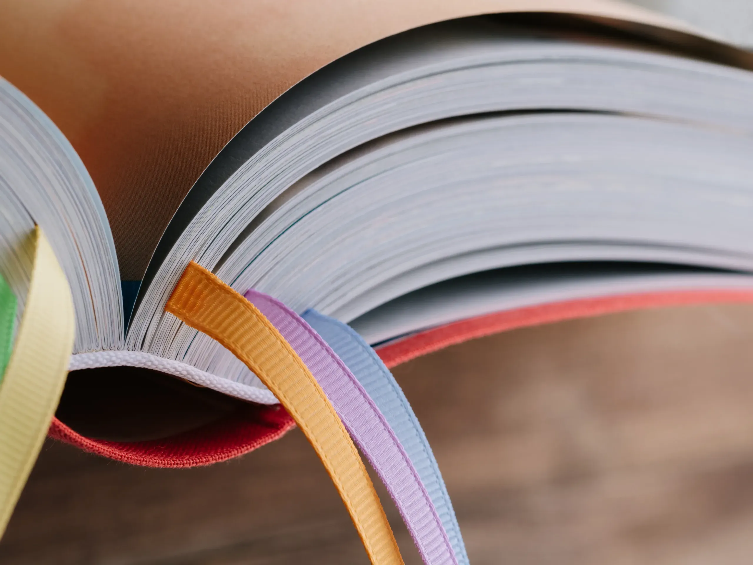 An open book with colourful ribbon bookmarks