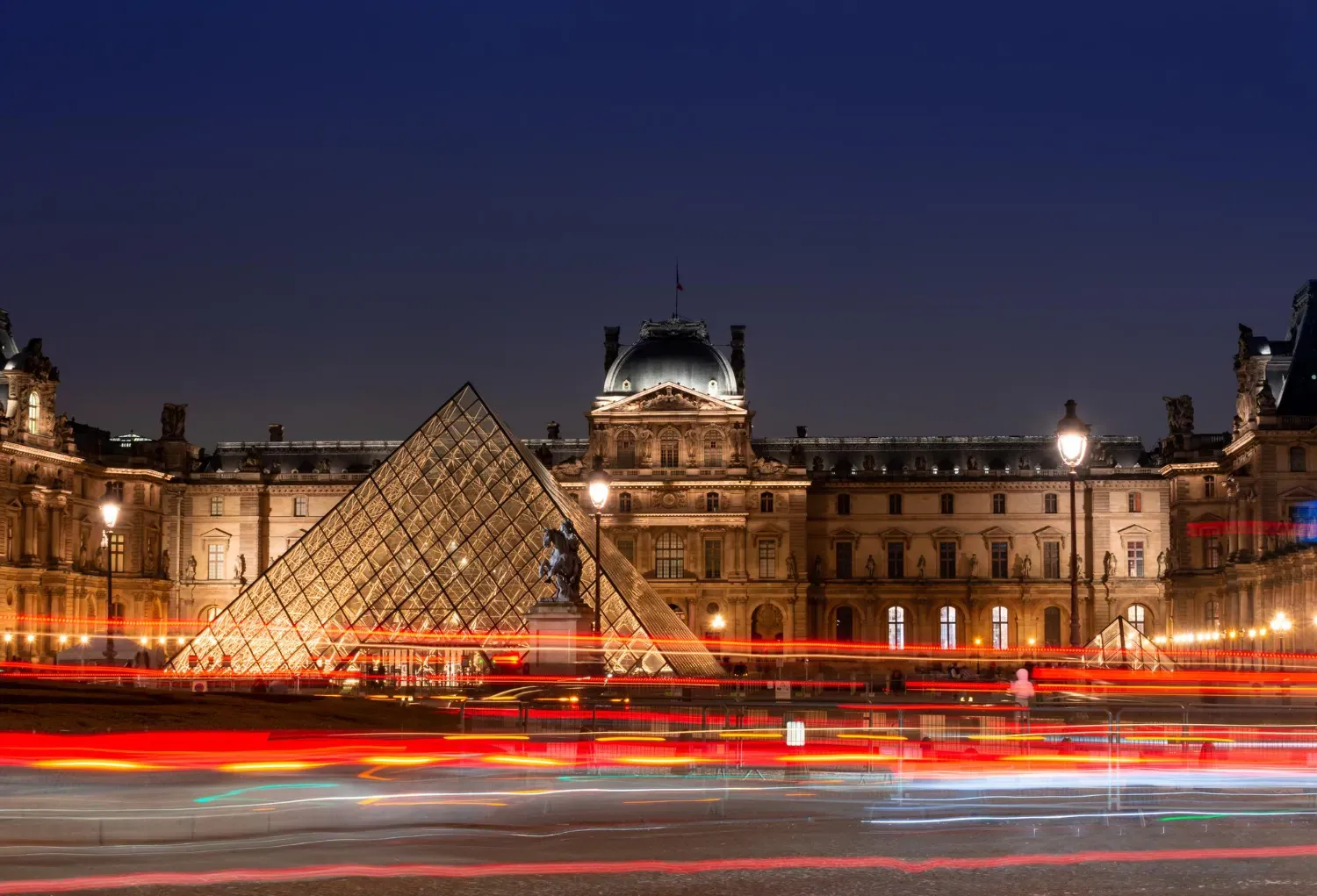 The Louvre and its glass pyramid illuminated at night